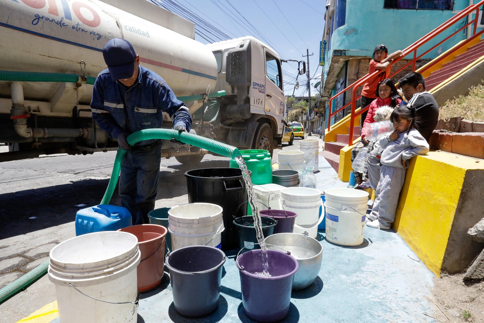 Un hombre llena unos recipientes con agua